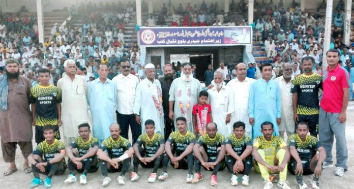 واجہ شہہ عبدالغنی بلوچ شہید فٹبال ٹورنامنٹ میں ہنٹر اسپورٹس کی ٹیم کا مہمان خصوصی حاجی عبدالمجید کے ساتھ گروپ فوٹو