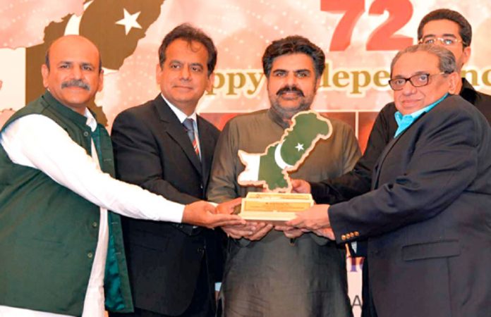 صوبائی وزیر ناصر حسین شاہ اور کمشنر کراچی افتخار شلوانی معروف تاجر سراج تیلی کو لائف ٹائم اچیومنٹ ایوارڈ دے رہے ہیں
