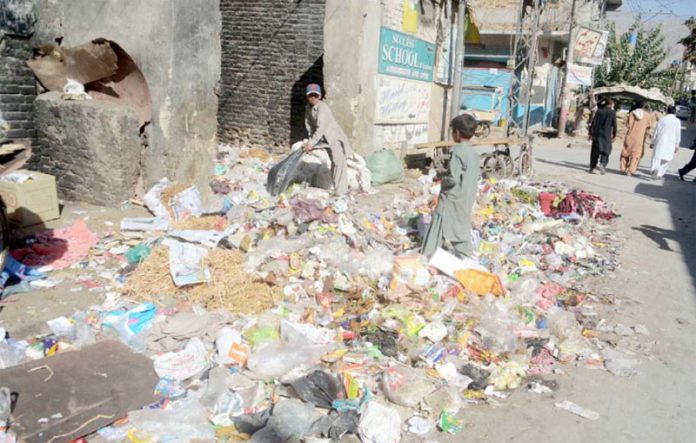 کوئٹہ ،مسجد روڈ کے سامنے جمع کچرے کے ڈھیر سے خانہ بندوش اپنے کام کی اشیا تلاش کررہا ہے
